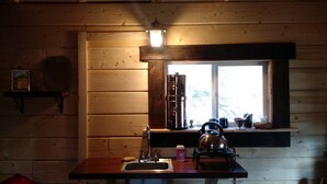 Cucina rustica con arredamento in legno, una finestra vista, un lavello e un bollitore sul bancone.