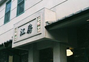 A building with a sign that reads "江房". - CōBō Hostel (Kyoto)