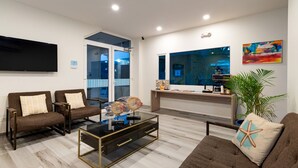 Una sala de estar moderna con dos sofás, una mesa de centro y un televisor de pantalla plana montado en la pared.