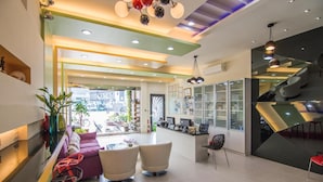 Un interior moderno con un mostrador de recepción, un área de estar y una escalera.