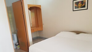 A bedroom with a bed, a wardrobe, a bathroom with a toilet and sink, and a framed picture on the wall. - Alona Bamboo House (Panglao)