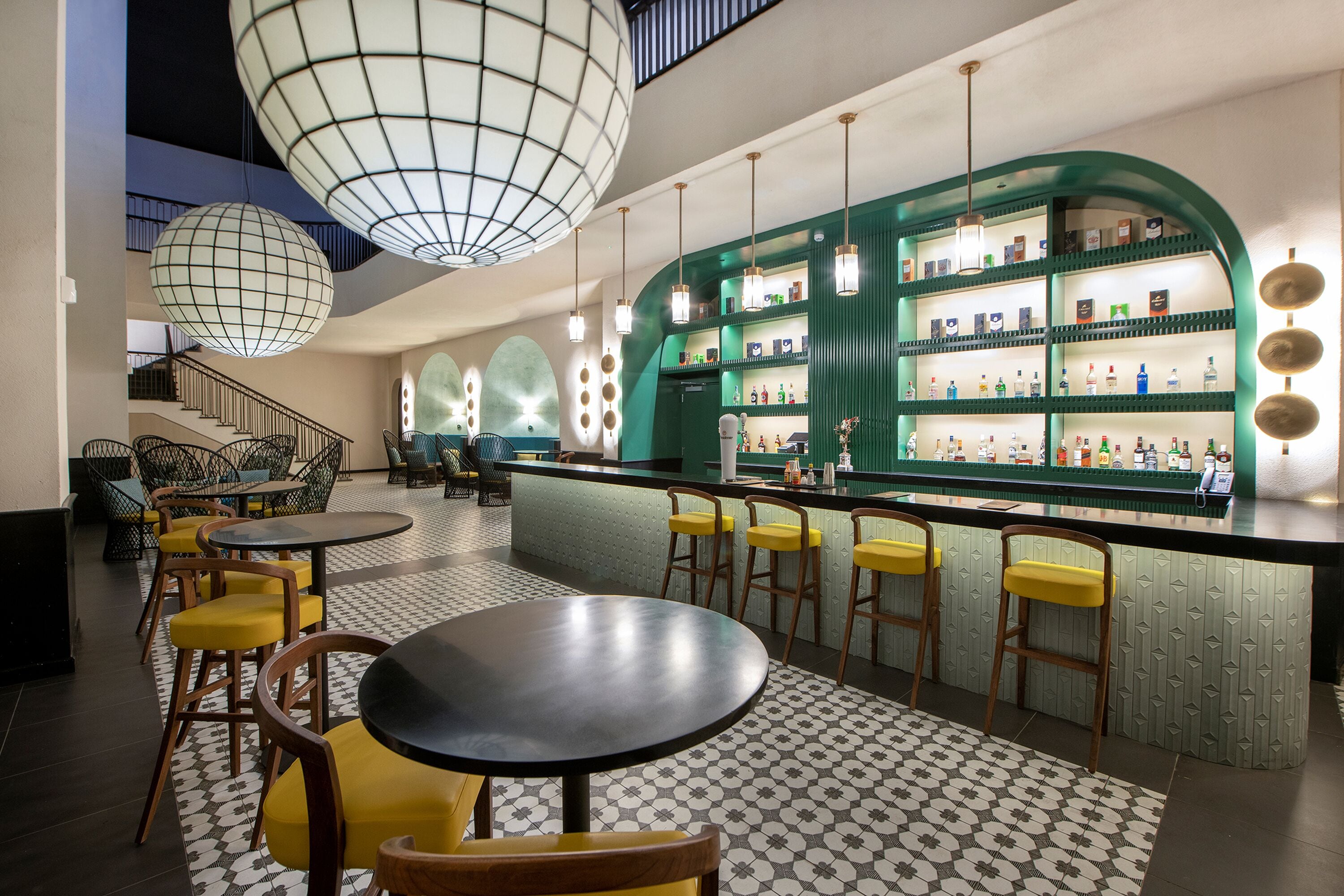 Un'area bar con un bancone, sgabelli e un pavimento decorato.