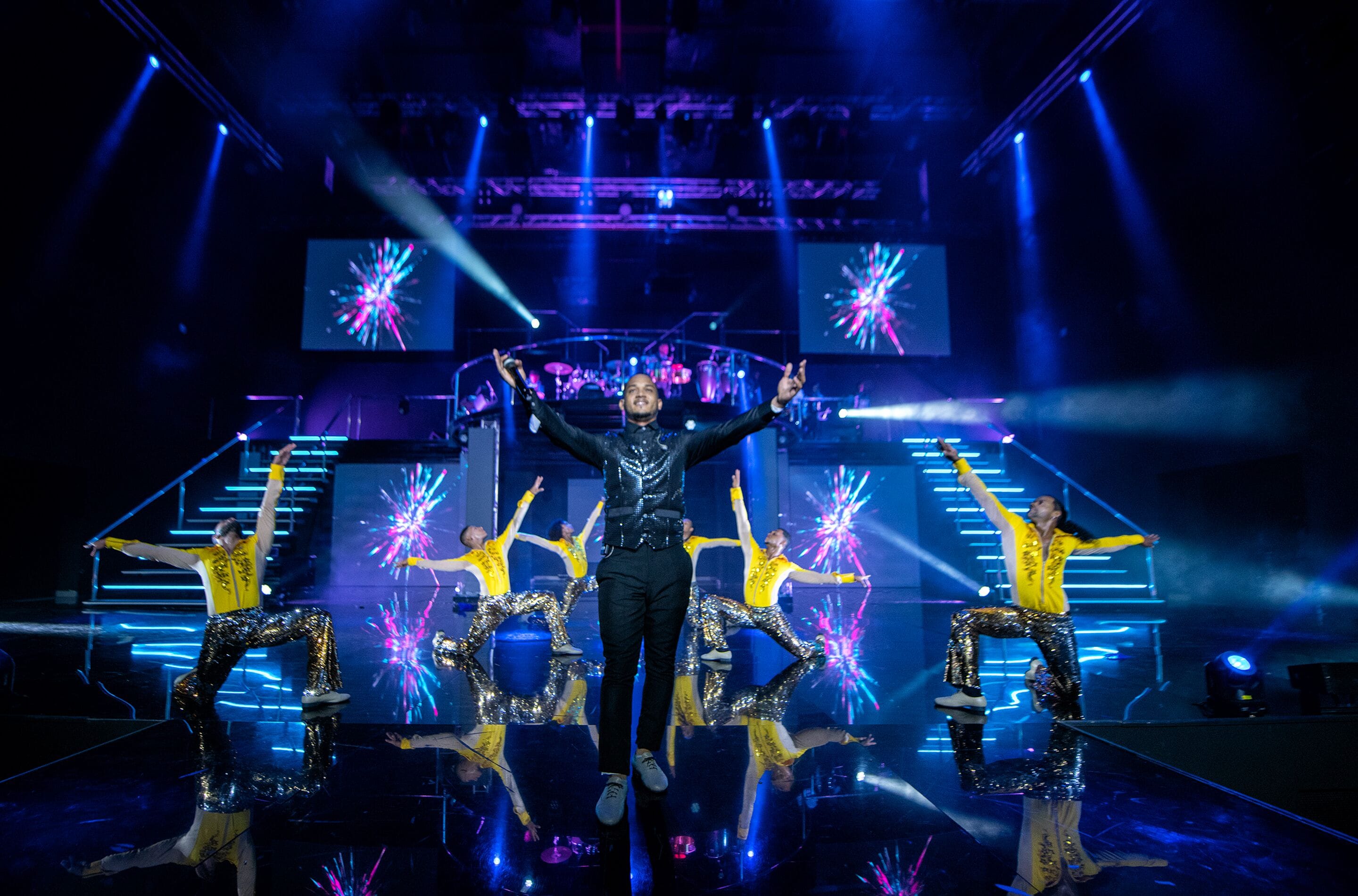 A stage with a performer in the center, surrounded by dancers.