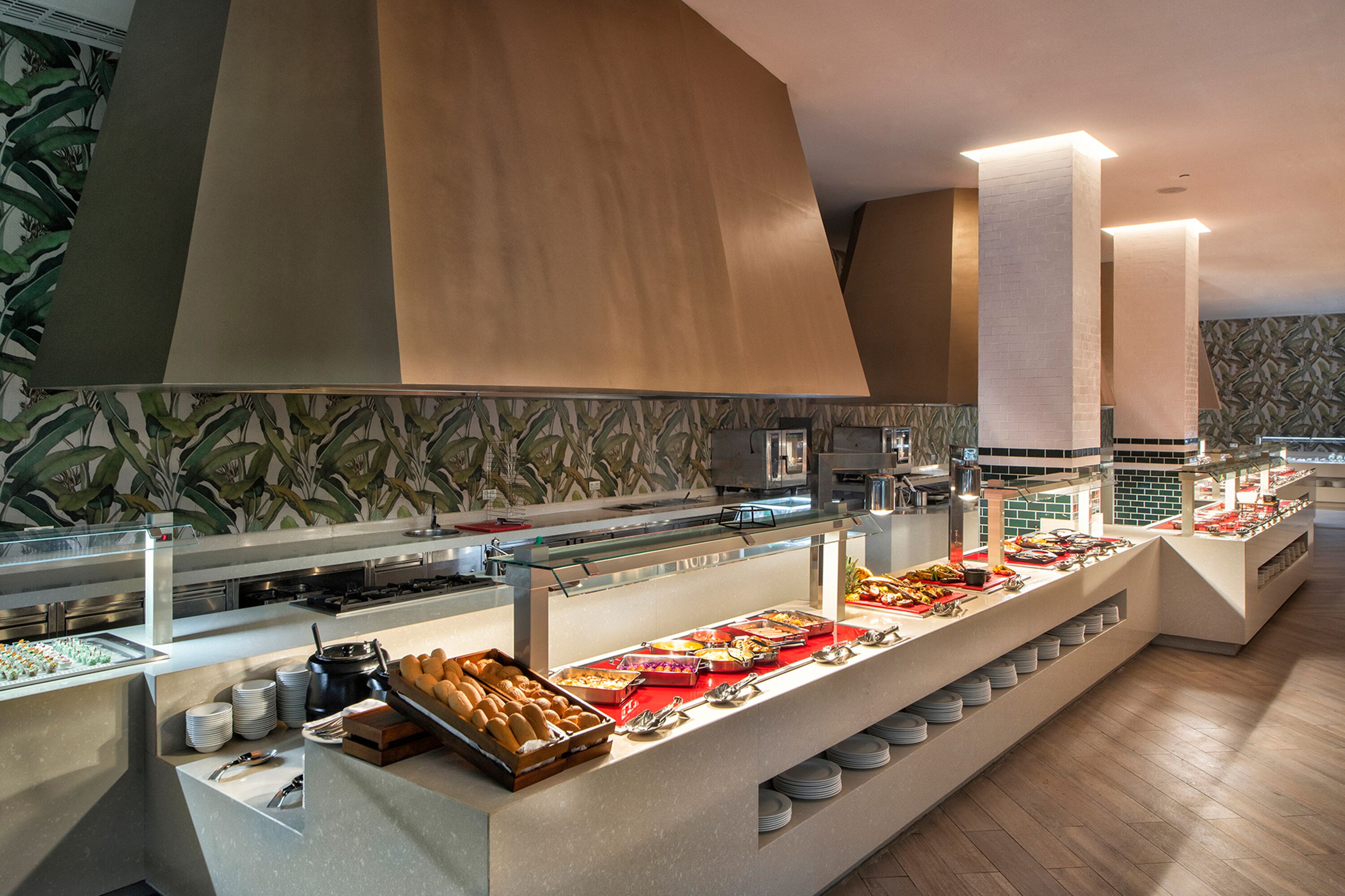 A buffet setup with various food items and a modern kitchen in the background.