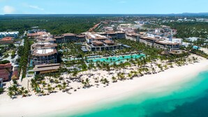 An aerial view of a resort with a beach, a pool area, and multiple buildings. - Unique by Lopesan Costa Bávaro - All Inclusive (Punta Cana)