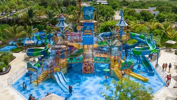 Enjoy water slides, play areas, and pools surrounded by lush greenery and palm trees.