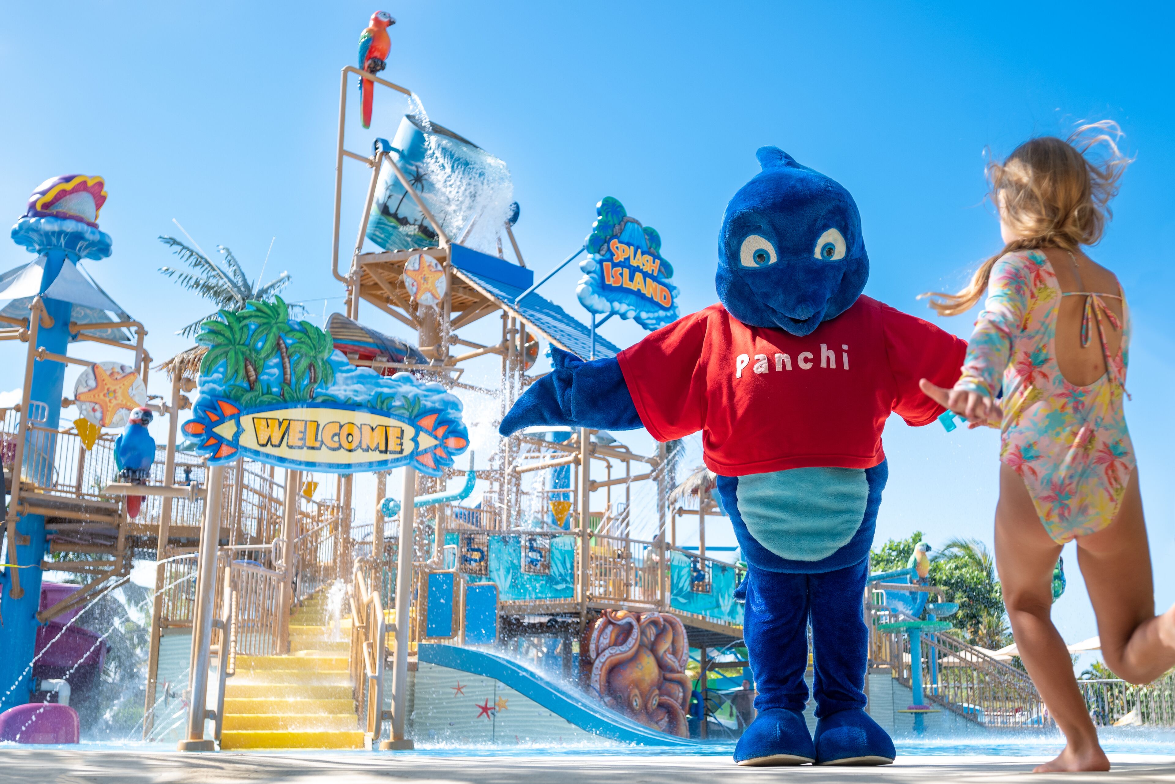 A water park with a mascot, a slide, and a sign that reads "Welcome".