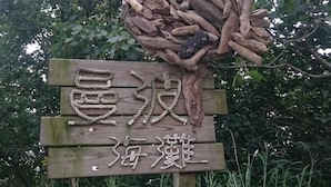Ein Holzschild mit chinesischen Schriftzeichen und einer Seilkulptur.