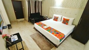 Een hotelkamer met een bed, een tafeltje met een dienblad en een stoel, plus een deur.