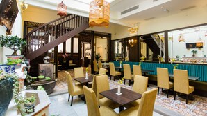 A spacious indoor area with a staircase, multiple seating arrangements, and hanging light fixtures. - Aava Malacca Hotel (Malacca City)