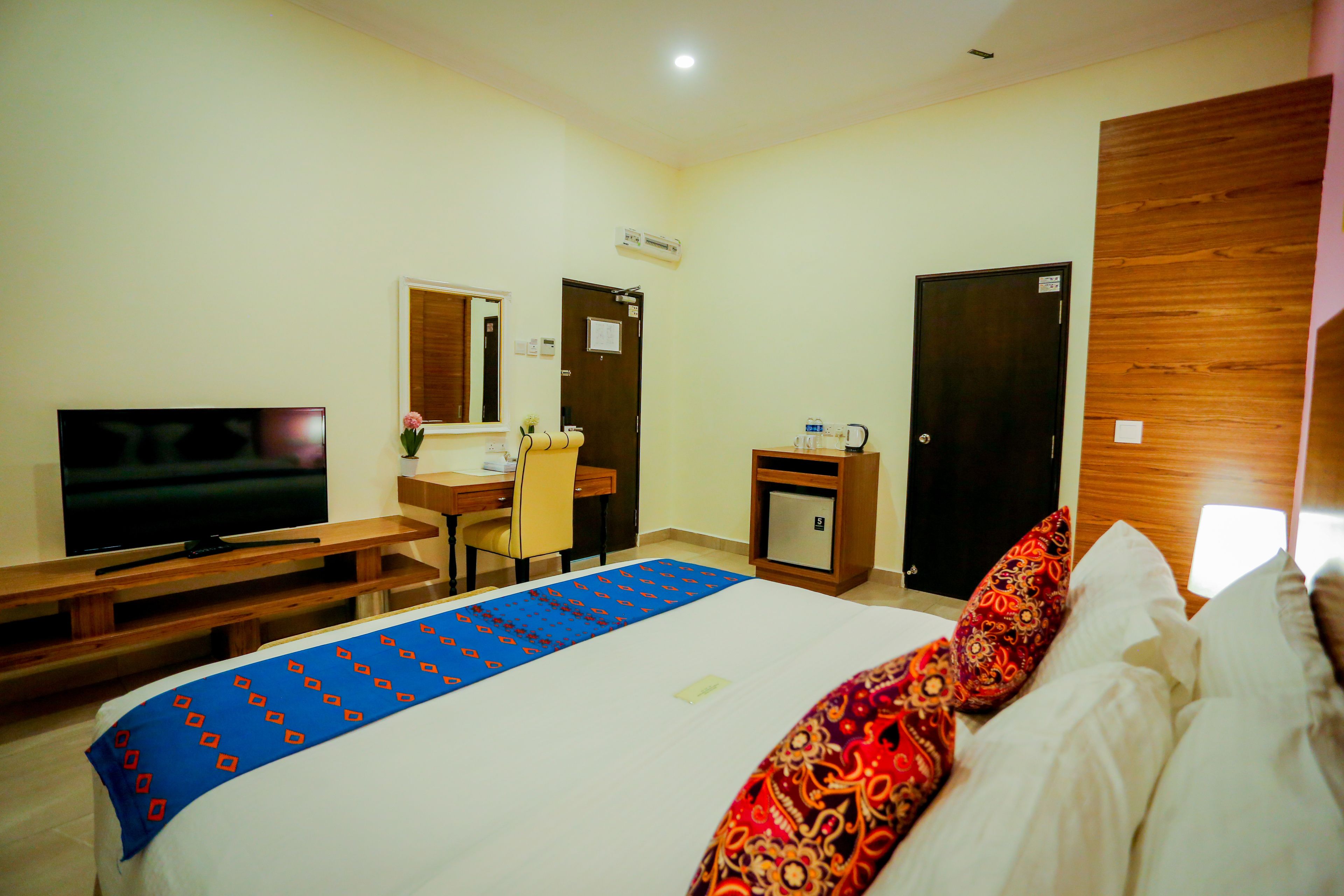 Una habitación de hotel con cama, televisión, escritorio y silla.
