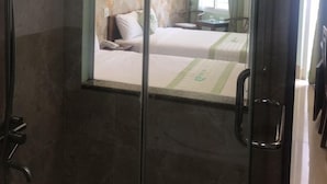 Une chambre d’hôtel avec une douche, un lit et un bureau.