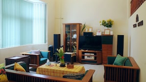 A living room with a sofa, a coffee table, a television, and a cabinet. - HomestyleHomestay (Jincheng)
