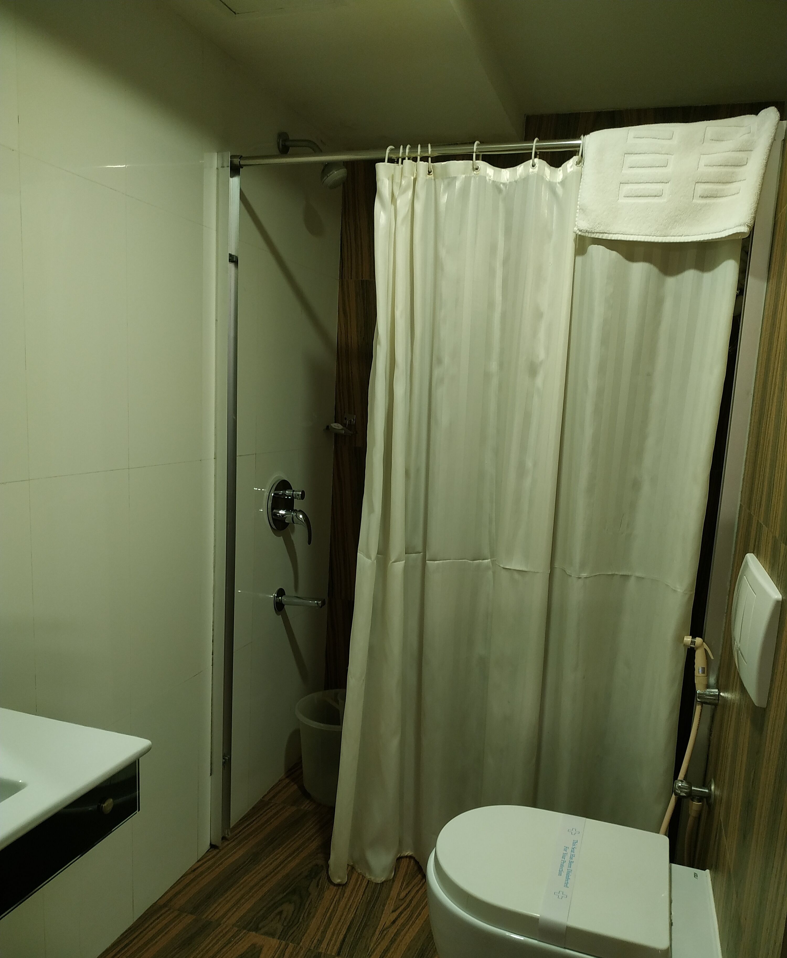 A bathroom with a shower curtain, a toilet, and a sink.