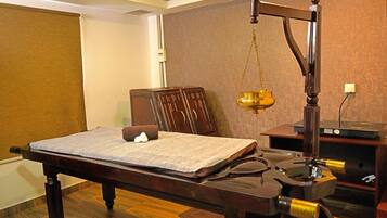 Classic room with a wooden bed, bedside table, and lamp.