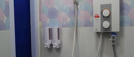 Baño con ducha, panel de control y ventana.