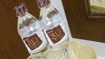 Dos botellas de agua con una etiqueta sobre una cesta tejida.