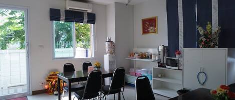 Una cocina moderna con una mesa de comedor, sillas y un refrigerador.