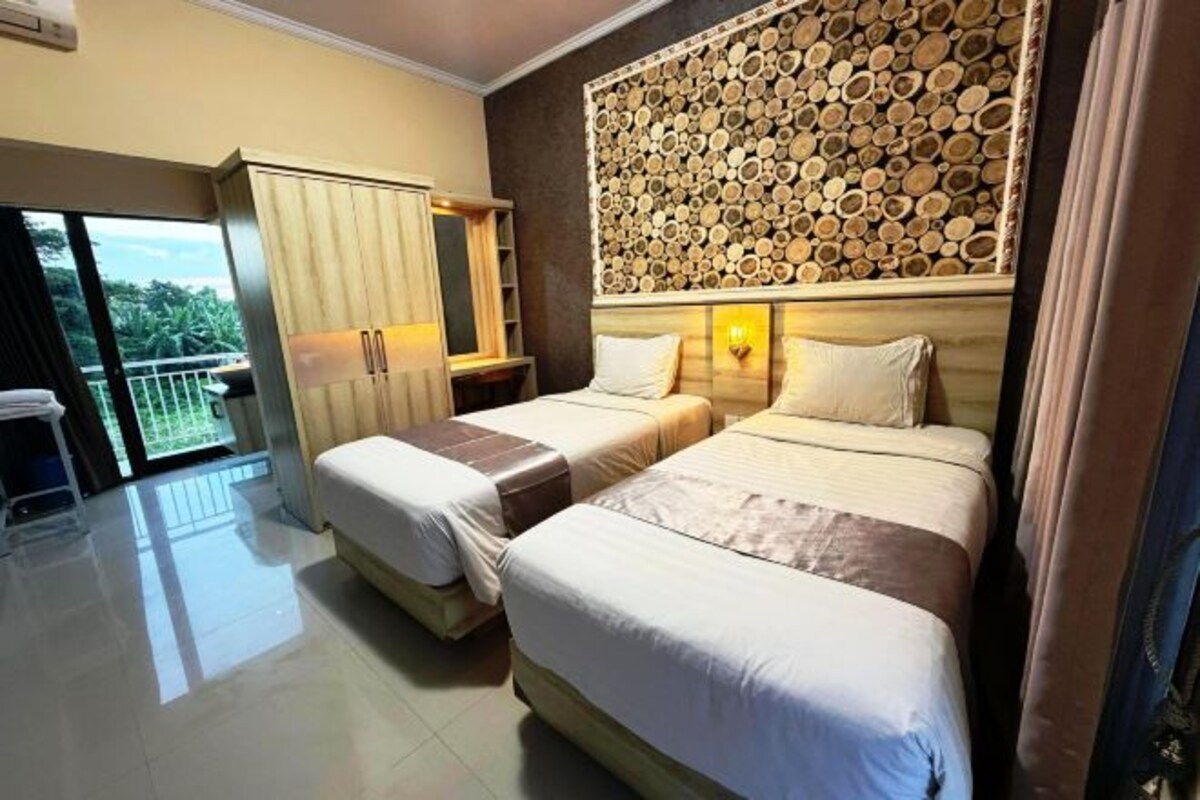 Una habitación de hotel con dos camas, un armario, un balcón y un adorno en la pared.