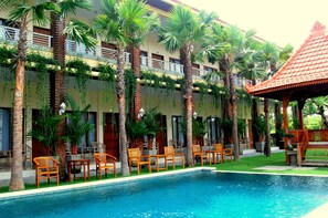 Una piscina al aire libre, sombrillas, sillones reclinables de piscina