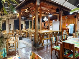 Un restaurante con mobiliario de madera, un reloj y un refrigerador.