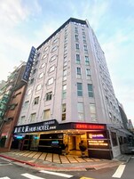Een meerlaags hotel met een opvallend bord voor 'Hub Hotel'.