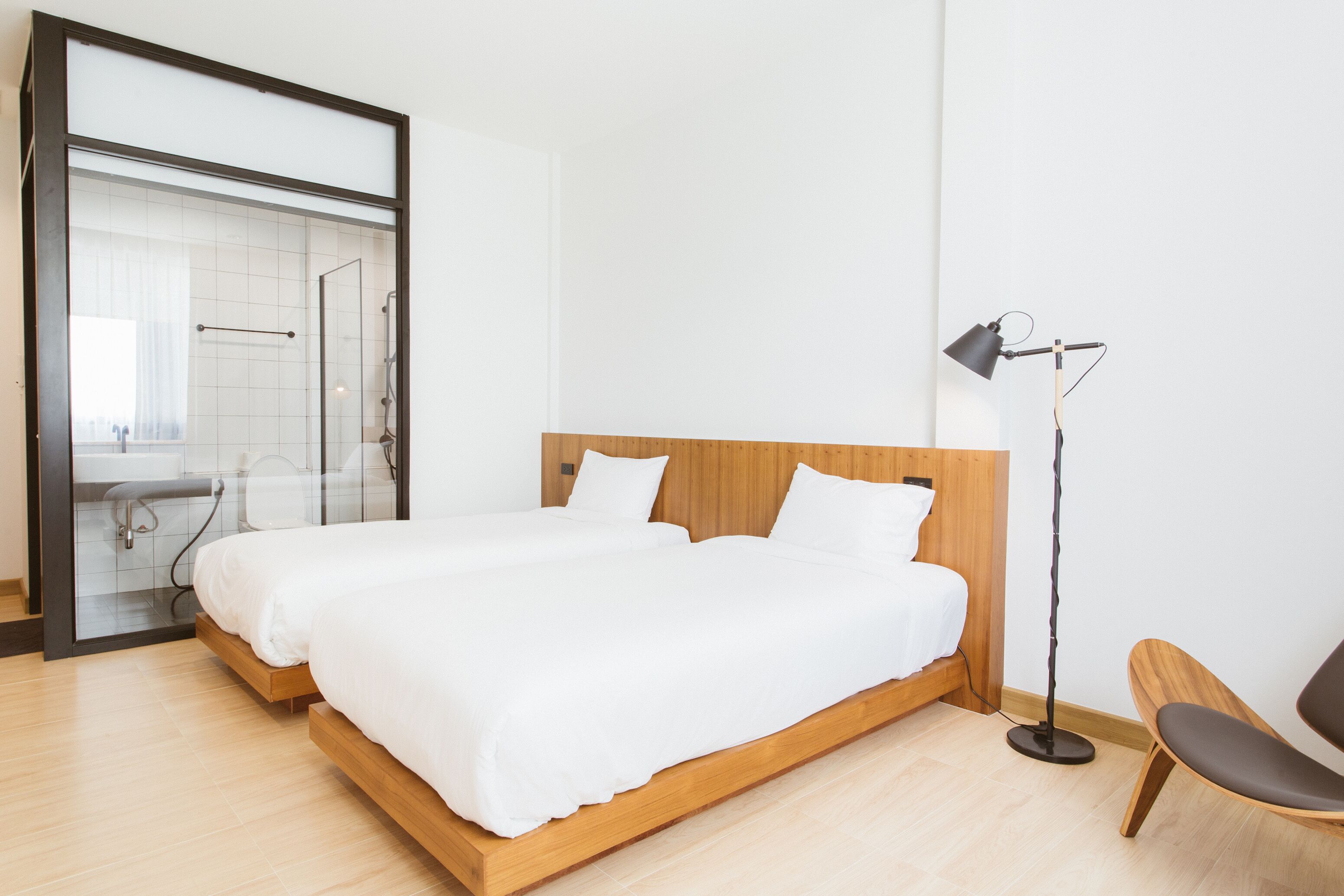 A modern bedroom with a large bed, a bedside lamp, and a chair.