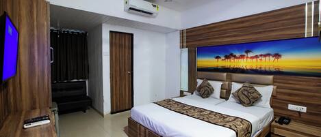 A hotel room with a bed, a TV, a ceiling fan, and an air conditioning unit.