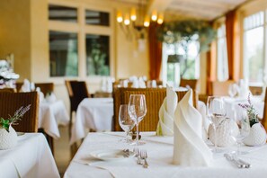 A dining area with tables set for a meal, featuring white tablecloths, silverware, and wine glasses. - Regiohotel Berghotel Ilsenburg (Ilsenburg)