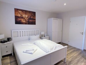 A neatly arranged hotel room with a bed, bedside tables, a wardrobe, and a painting on the wall. - Regiohotel Berghotel Ilsenburg (Ilsenburg)