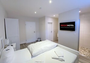 A hotel room with a bed, a TV, and a wall-mounted sign. - Regiohotel Berghotel Ilsenburg (Ilsenburg)
