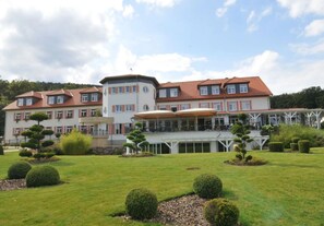 A large, multi-story hotel with a central courtyard and manicured gardens.