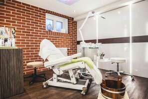 Una clínica dental moderna con pared de ladrillo, un sillón dental, una lámpara de tratamiento y un cubo de madera.