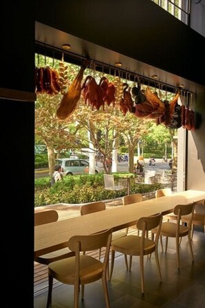 A restaurant with a long table and chairs, a hanging meat display, and a view of the street outside. - CitiGO Hotel Jingan Shanghai (Shanghai)
