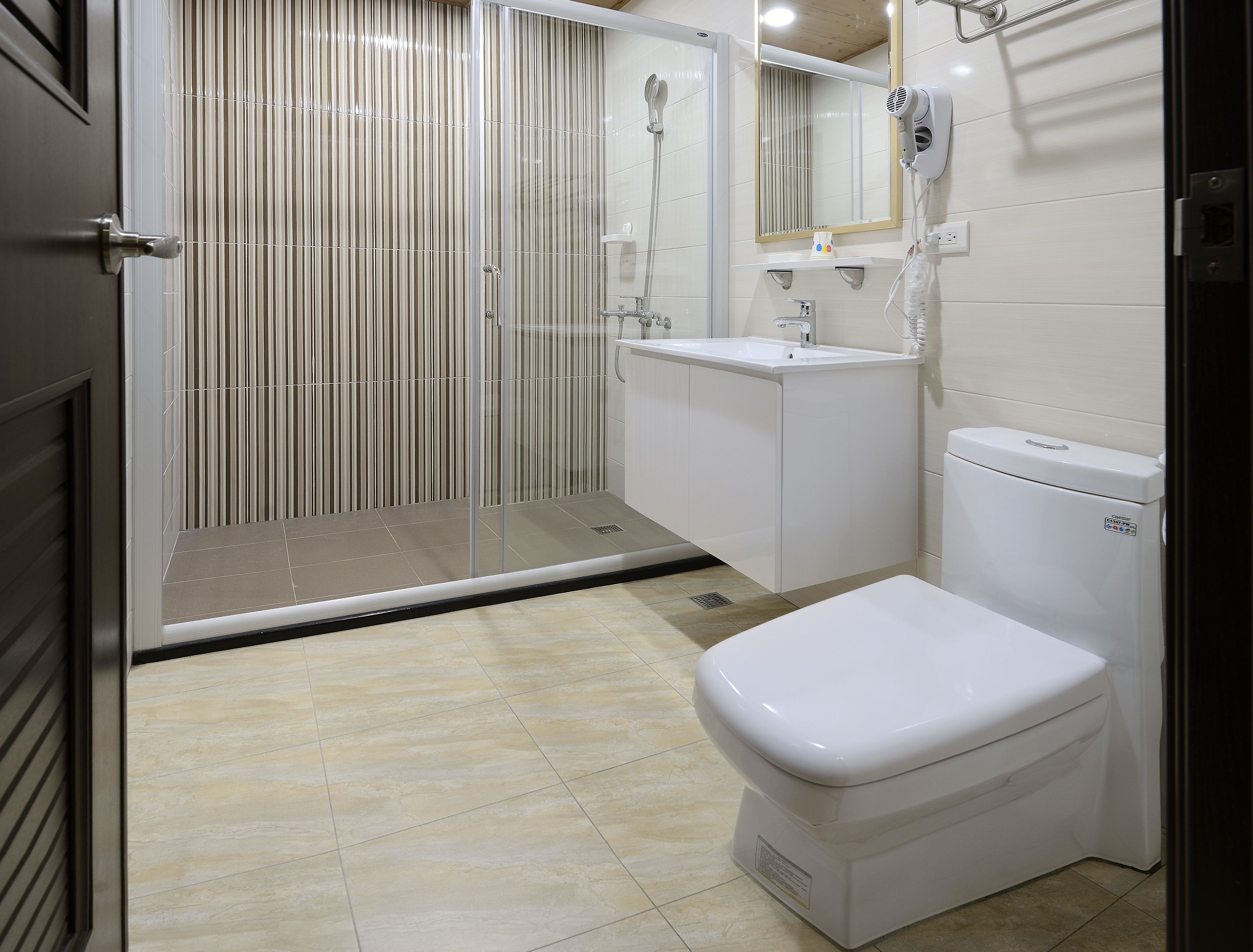 A modern bathroom with a shower, toilet, and sink.