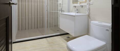 A modern bathroom with a shower, toilet, and sink.