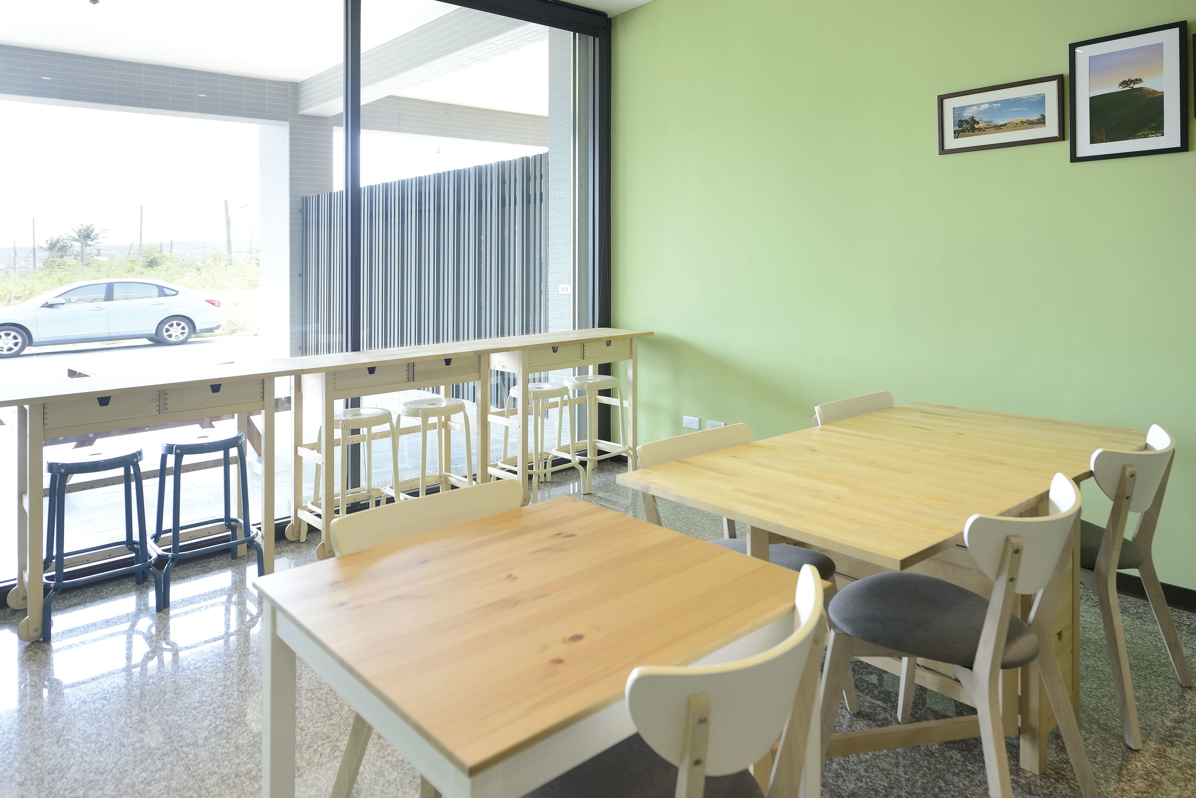 A room with a large window, a wooden table, and chairs.