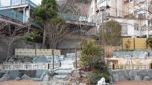 A traditional Japanese garden with a koi pond, stone lanterns, and a wooden deck. - Kinugawa Kokusai Hotel (Nikko)