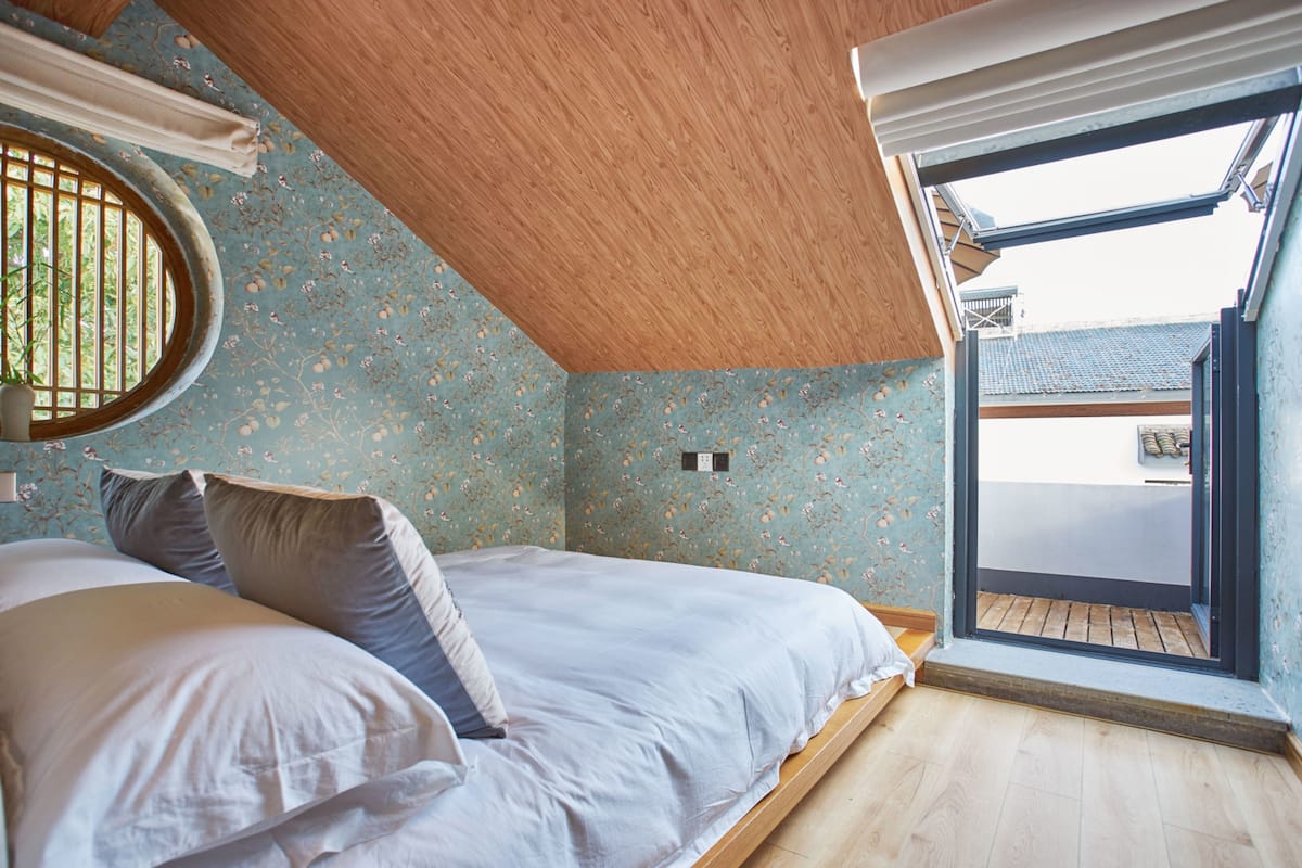 Een slaapkamer met een bed, een raam en uitzicht.