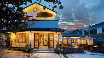 Traditional building with a welcoming entrance, surrounded by a lush garden and seating area.