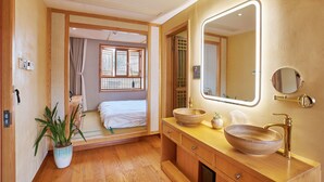 Une salle de bain moderne avec un meuble-lavabo en bois, un grand miroir et un lavabo en forme de coupe.