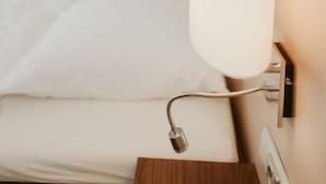 A hotel room with a bed, a bedside lamp, and a wall-mounted light fixture. - Hotel Meyer (Hildesheim)