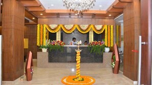 A reception area with a chandelier, floral decorations, and a reception desk.