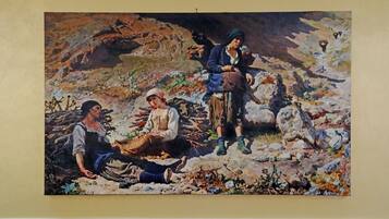 A painting of three figures in a rocky outdoor setting.