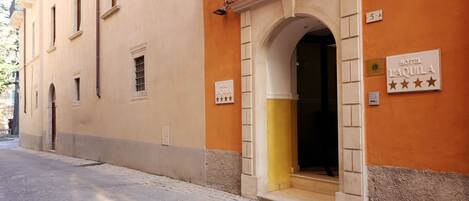 A building with a sign reading "HOTEL LAQUILA" and a rating of four stars.