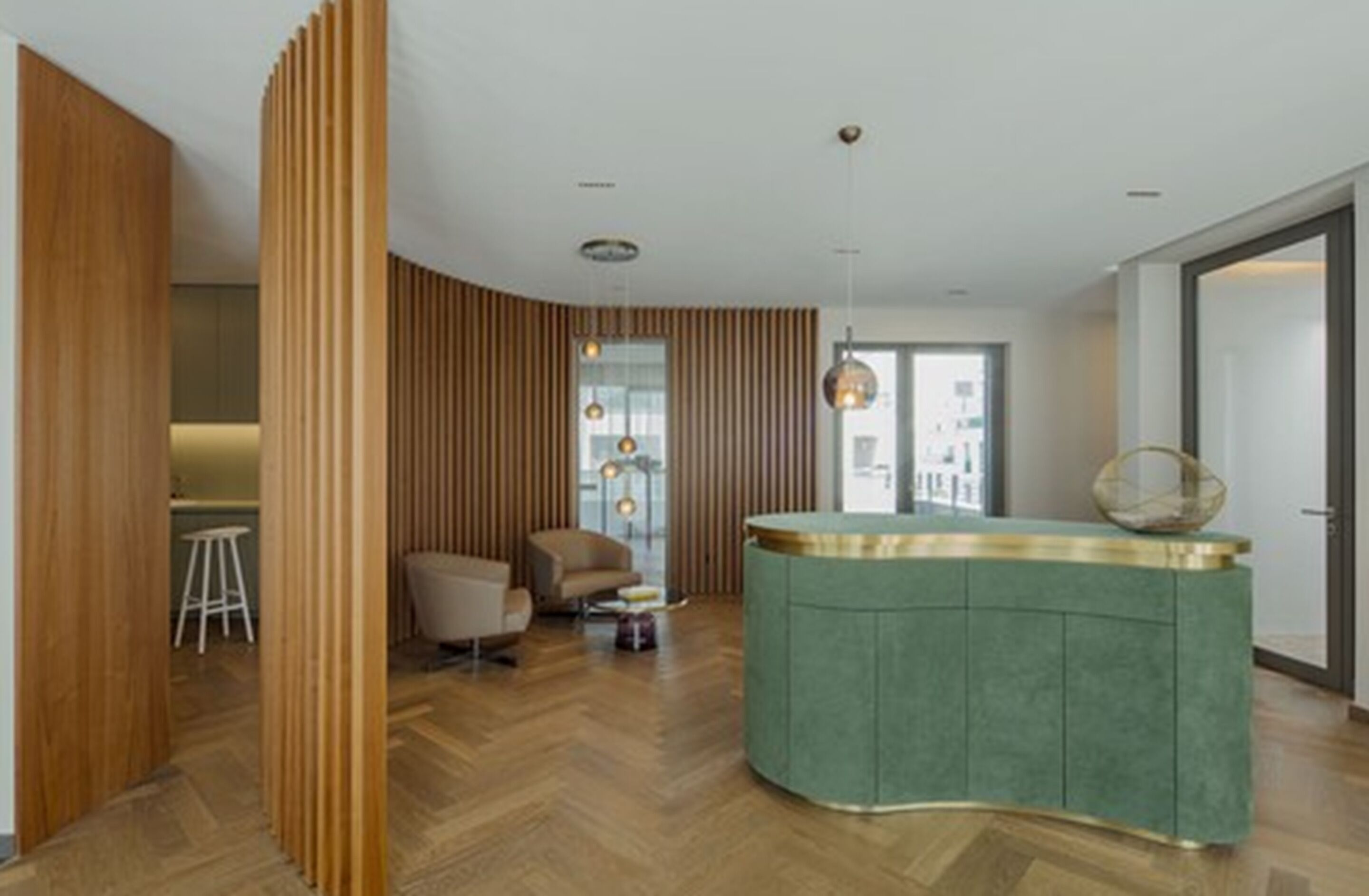 Un salon moderne avec un canapé vert aux lignes courbes, un mur d’accent en bois et un plancher en bois.