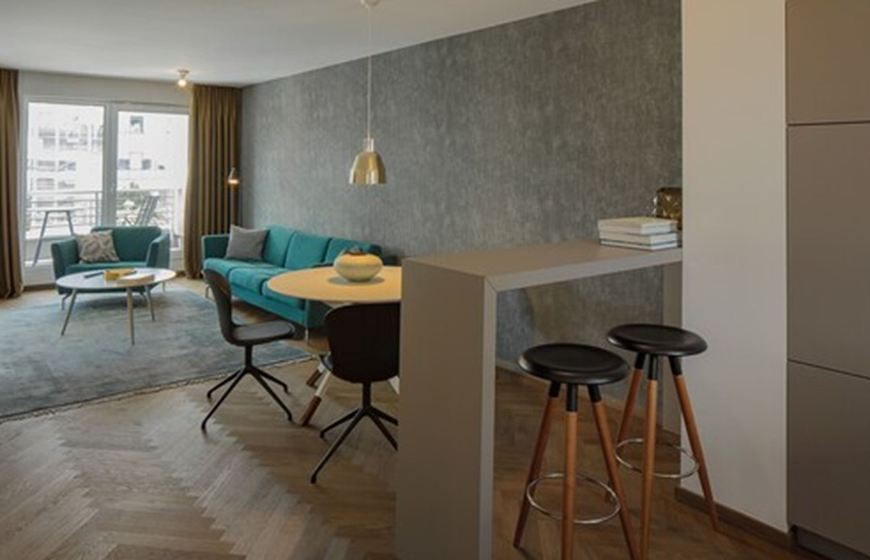Una sala de estar moderna con un sofá, una mesa de centro y un comedor con taburetes.