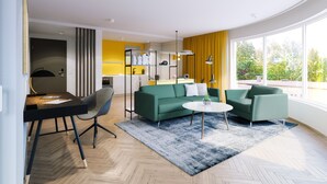 A modern living room with a green sofa, a round coffee table, and a dining area with a black table and chairs. - DD Suites Serviced Apartments (Munich)