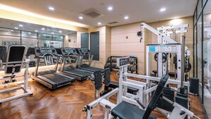A gym with treadmills, weight machines, and a mirrored wall. - JK Blossom Hotel (Seoul)