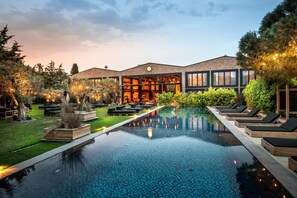A modern hotel with a large infinity pool, outdoor seating, and a well-maintained garden. - Warehouse By The Stay (Cesme)